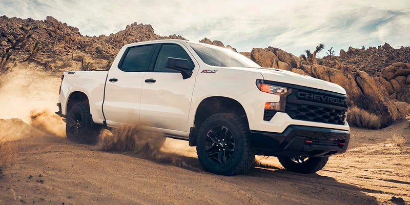 White Chevrolet Silverado driving in desert.